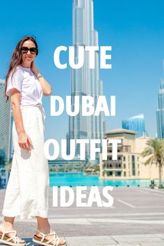 a woman standing in front of a tall building with the words cute dubai outfit ideas