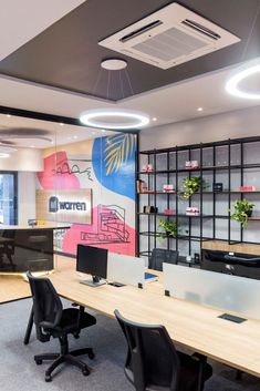 an office with two desks and chairs in front of a wall mounted sign that says women