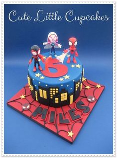 a birthday cake with spiderman figures on it and the number five in the middle