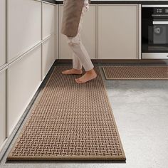 a person standing on the kitchen floor in front of an oven