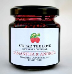 a jar of raspberry preserves sitting on top of a white tablecloth with the words spread the love in it