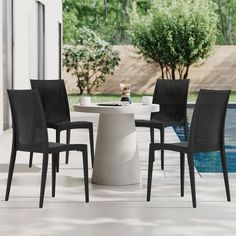 a white table with four black chairs next to a swimming pool in a backyard area