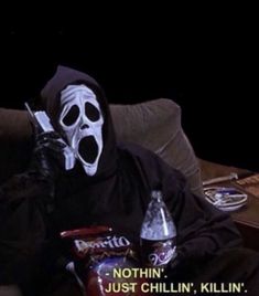 a person wearing a mask sitting on a couch with two sodas in front of them