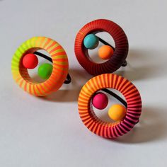 three colorful rings with balls on them sitting on a white table next to each other