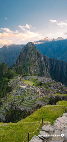 the ruins of machu picchul are surrounded by green grass and mountains in the background