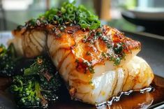 seared scallops on a plate with broccoli and other items in the background