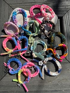 several different colored bracelets on a wooden surface