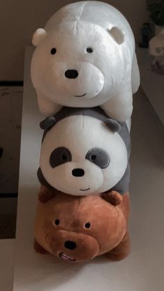 three stuffed animals are stacked on top of each other in the shape of a bear