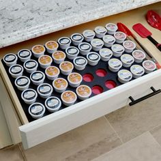 an open drawer with various items in it and utensils on the bottom shelf