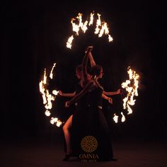 two women are dancing with fire in their hands at the same time, and one woman is wearing a black dress