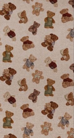 a group of teddy bears sitting on top of a white ground covered in brown and green fabric