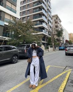 a woman standing in the middle of a street