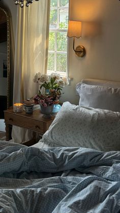 a bedroom with a bed, nightstand and window in it's centerpieces