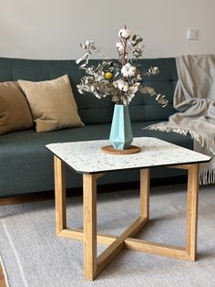 a living room with a couch, table and flowers on the coffee table in front of it