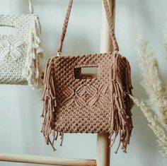 two crocheted purses hanging on a wooden chair