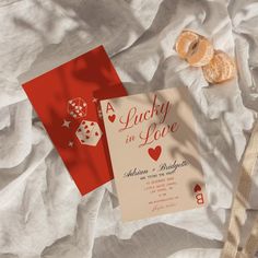 two cards with hearts and dice on them sitting next to each other, surrounded by white sheets