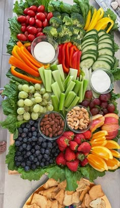 a platter filled with fruits, vegetables and crackers