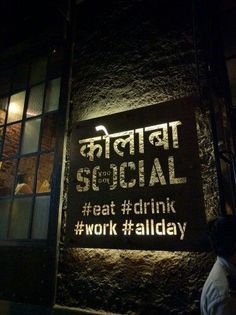 a sign on the side of a building that says social and eat drink work all day