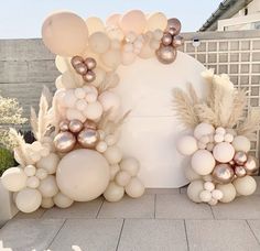 an outdoor area with balloons and plants on the ground, in front of a building