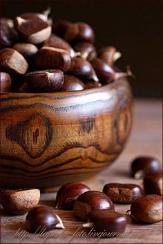 some nuts are in a wooden bowl on a table