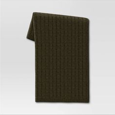 a dark green scarf with small squares on the front and back, folded in two rows