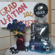 two vases with flowers are sitting on a table next to a sign that says graduation