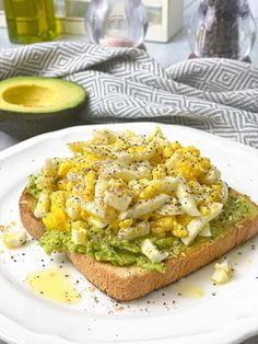 an avocado and egg sandwich on a white plate