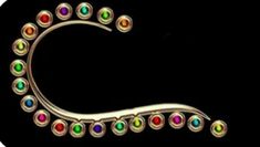 a gold brooch with multicolored stones in the shape of a letter c