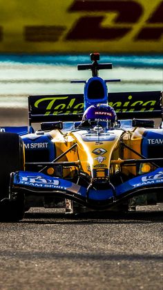 a blue and yellow race car driving down the track