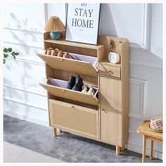 a wooden shelf with baskets and shoes on it in front of a white wall that says stay home