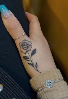 a woman's hand with a rose tattoo on it