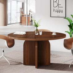 a round wooden table with two chairs and a potted plant on the end, in an office setting