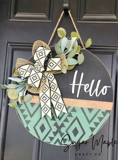 a door hanger that says hello on it with a bow hanging from the front