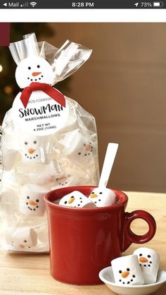 two snowman marshmallows in a red mug