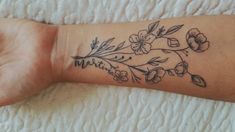 a woman's arm with flowers on it and the word mother written in cursive writing