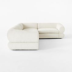 a white couch sitting on top of a white floor