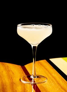 a martini glass sitting on top of a wooden table