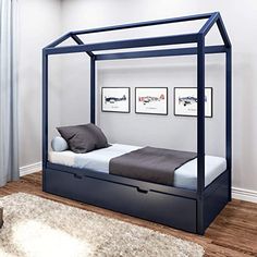 a bed with a canopy and drawers underneath it