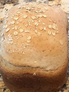 a loaf of bread sitting on top of a cooling rack with oatmeal bread