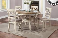 a dining room table with four chairs and a clock on the wall behind it in front of a window