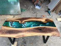 a table made out of wood with blue and green paint on it's surface