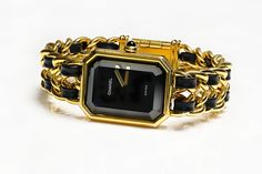 Chanel Premiere Ladies Watch.Vintage Chanel Premier yellow gold plated case, black lacquered dial, ogive-cut onyx cabochon crown, gold plated chain bracelet interwoven with black leather ribbons. Chanel Premiere watch was created back in 1987 by Jacques Helleu, being the first timepiece for Chanel. It’s rectangular case was inspired by the Chanel No.5 perfume bottle stopper and the shape of Place Vendome, located in Paris, France. Gender: Ladies Display: Analog Model: Premiere 1987 Shape: Rectan Luxury Vintage Black Watch Accessories, Luxury Retro Black Watch Accessories, Luxury Black Classic Jewelry And Watches, Luxury Black Timeless Watch Accessories, Luxury Timeless Black Watch Accessories, Luxury Black Timeless Jewelry And Watches, Luxury Black Jewelry With Rectangular Dial, Womens Chanel Watch, Luxury Vintage Black Watches