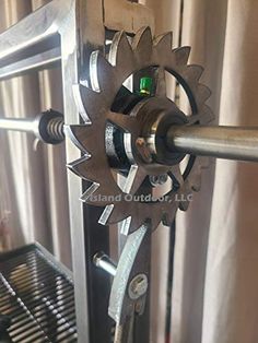 a machine that is sitting on top of a metal rack and has gears attached to it