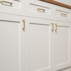 white cabinets with brass handles in a kitchen