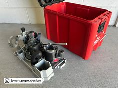 a red box with some tools in it and another container on the floor next to it