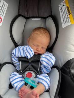 a baby sleeping in a car seat with its head on the back of it's arm