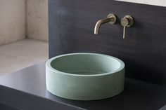 a bathroom sink sitting on top of a black counter next to a faucet