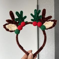 someone is holding up a headband made to look like reindeer ears with cherries on them