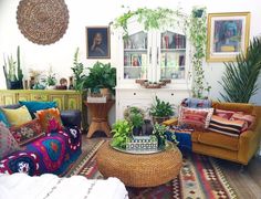 a living room filled with lots of furniture and plants