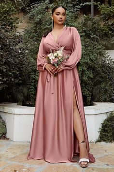 a woman in a long pink dress posing for the camera